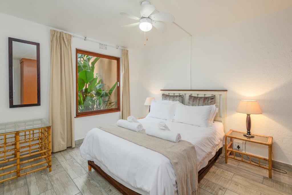 a bedroom with a bed with white sheets and a window at San Lameer Villa 1914 - 2 Bedroom Classic - 4 pax - San Lameer Rental Agency in Southbroom