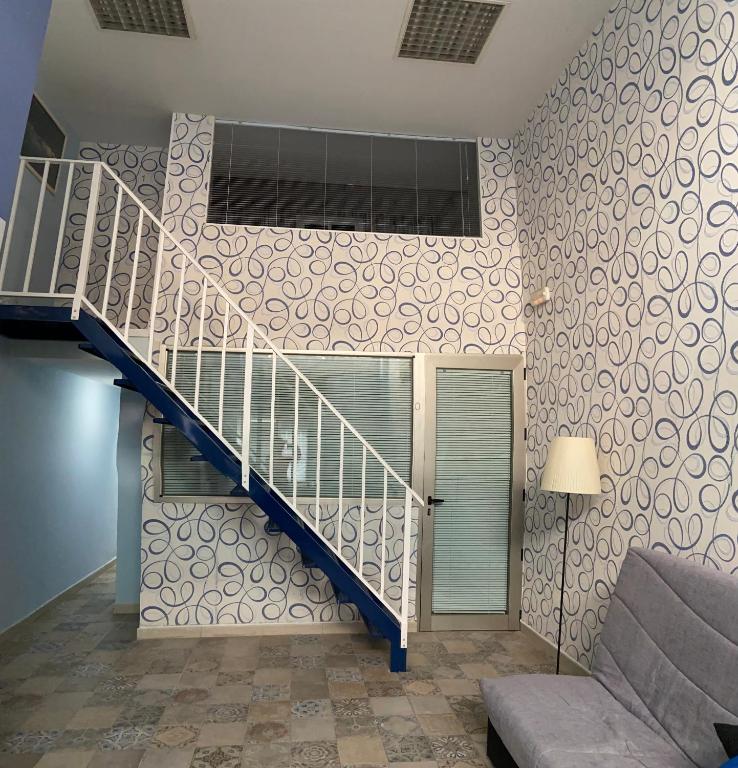 - un escalier dans le salon avec un canapé dans l'établissement Urban Loft, à Alcorcón