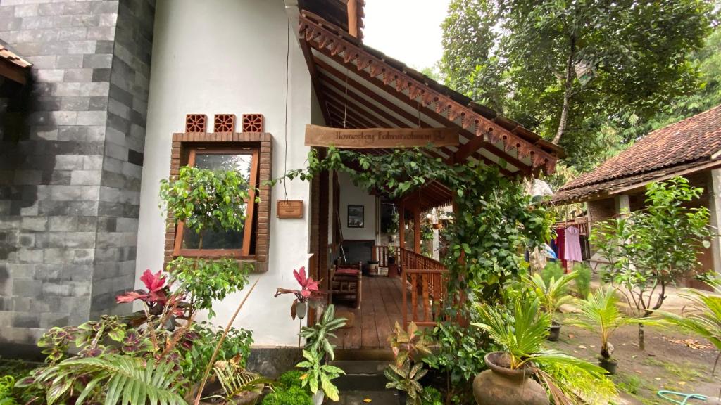 ein Haus mit einer Veranda mit Pflanzen davor in der Unterkunft Homestay Candi Pawon Fahrurohman Syariah in Mendut