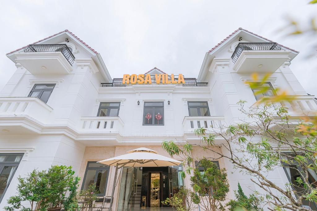 a white building with an orange sign on it at ROSA VILLA & HOTEL Dalat in Da Lat