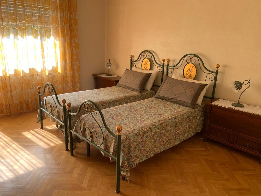 sypialnia z 2 łóżkami i drewnianą podłogą w obiekcie Il Salottino di San Paolo w Rzymie