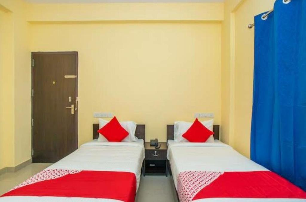 2 camas con almohadas rojas en una habitación en HOTEL SLN INN en Bangalore