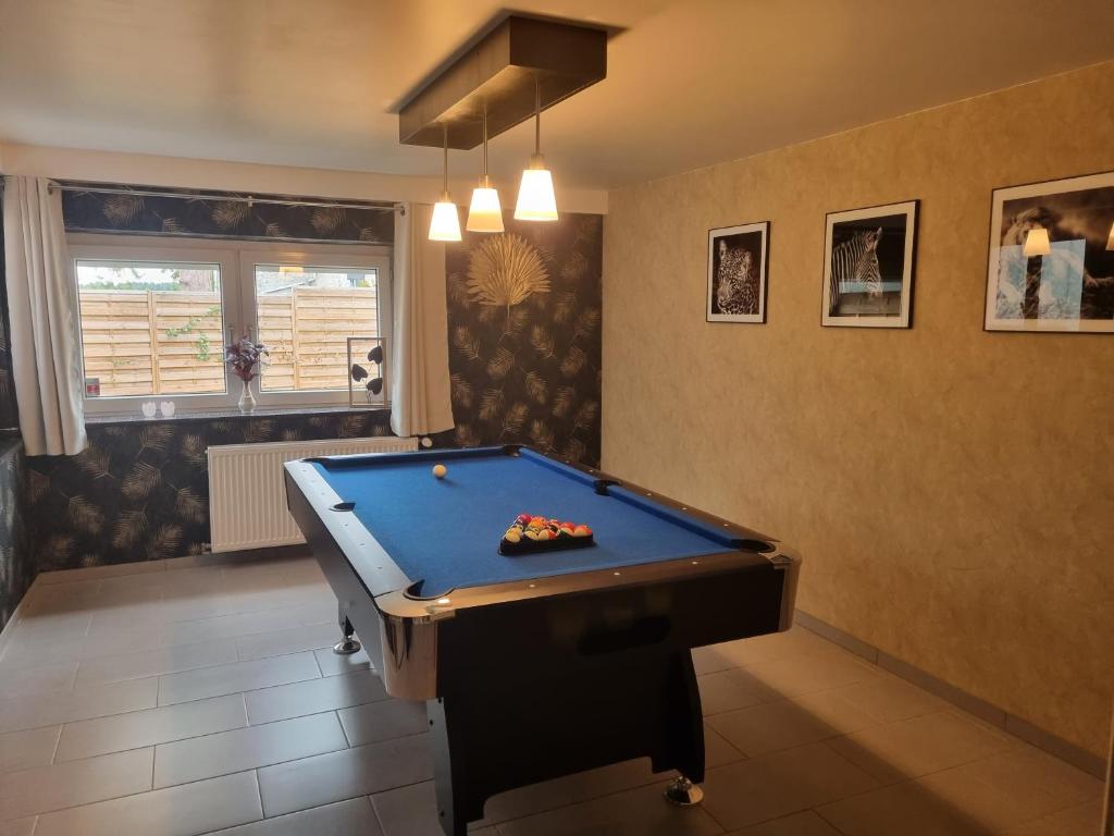 a pool table in a living room with a pool at Maison de vacances aux portes des Fagnes in Hamoir