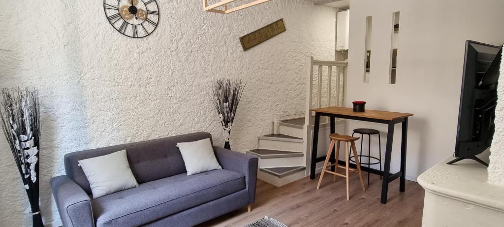 ein Wohnzimmer mit einem Sofa und einem Tisch in der Unterkunft Superbe studio entre vieille-ville et Stanislas in Nancy