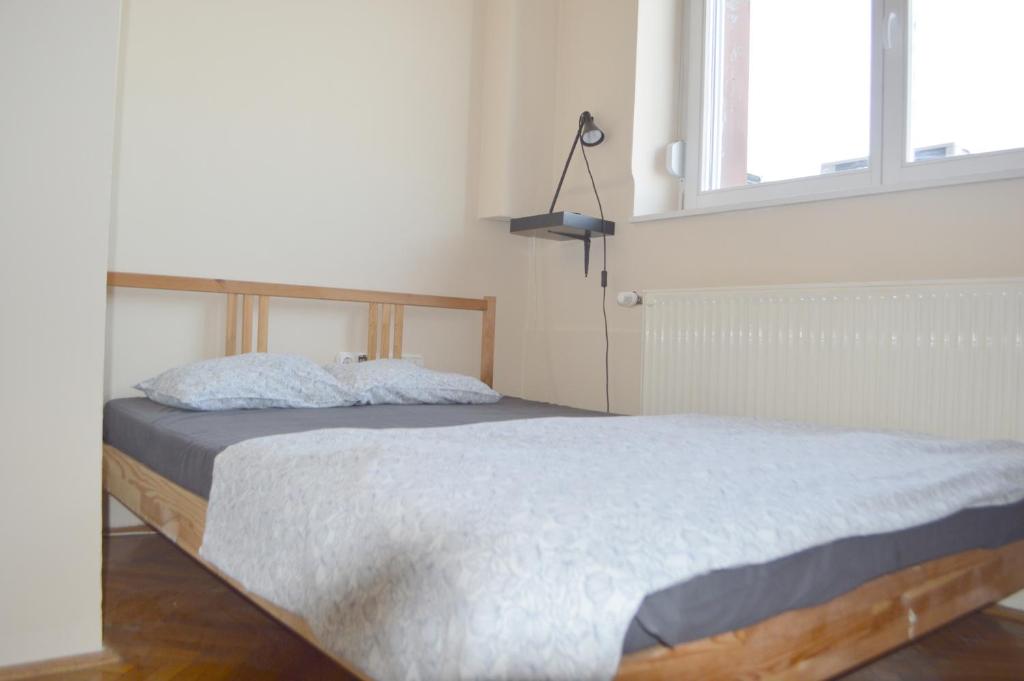 1 dormitorio con 1 cama en una habitación con ventana en Artist Guest House, en Budapest