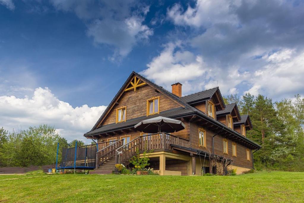 una gran casa de madera en la parte superior de un campo en ORLIK - pokoje gościnne, en Uście Gorlickie