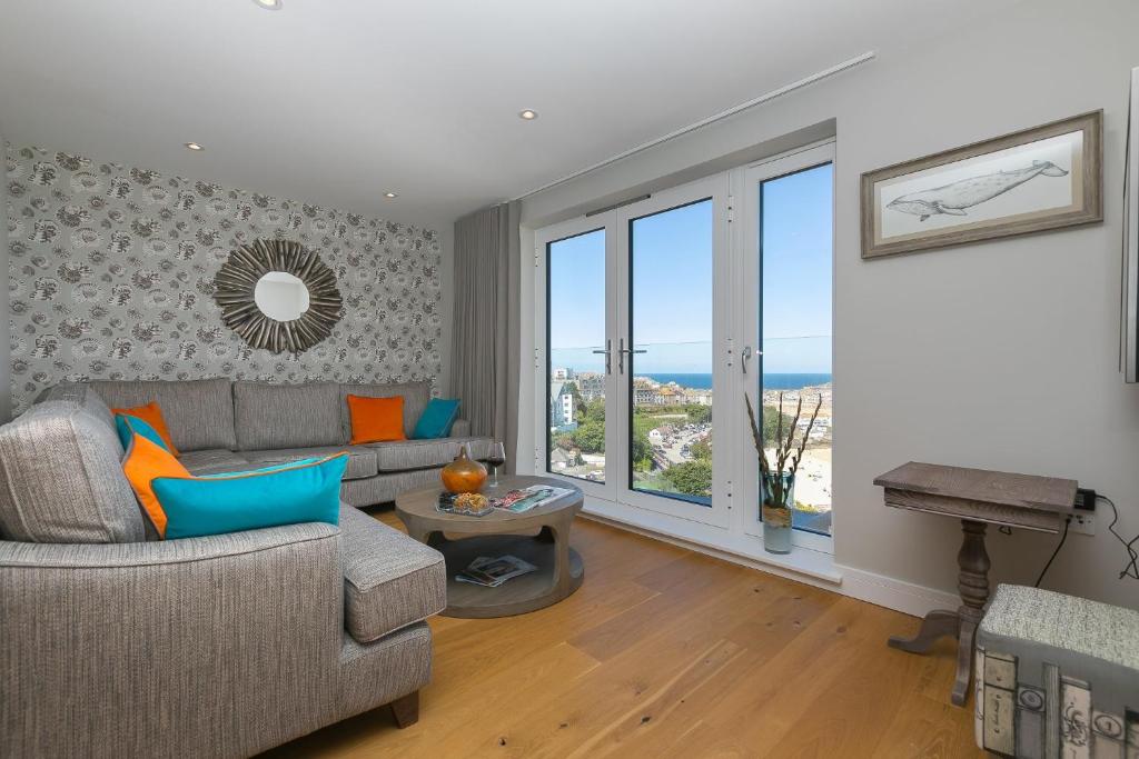 una sala de estar con un sofá y una mesa en The Pearl, en St Ives