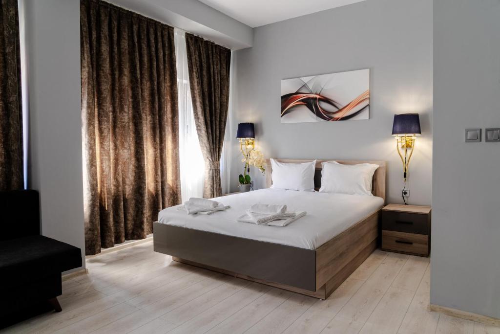 een slaapkamer met een groot bed en een raam bij Cappo Aparthotel in Veliko Tŭrnovo