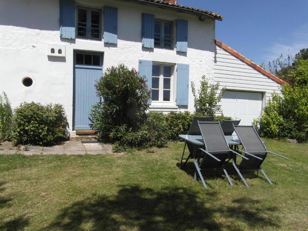 una mesa y sillas frente a una casa en GITE A LA FERME en Le Pin-Saint-Denis