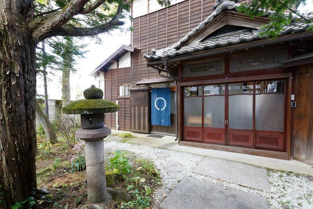 um banho de pedra em frente a um edifício em AI/藍 em Kusatsu