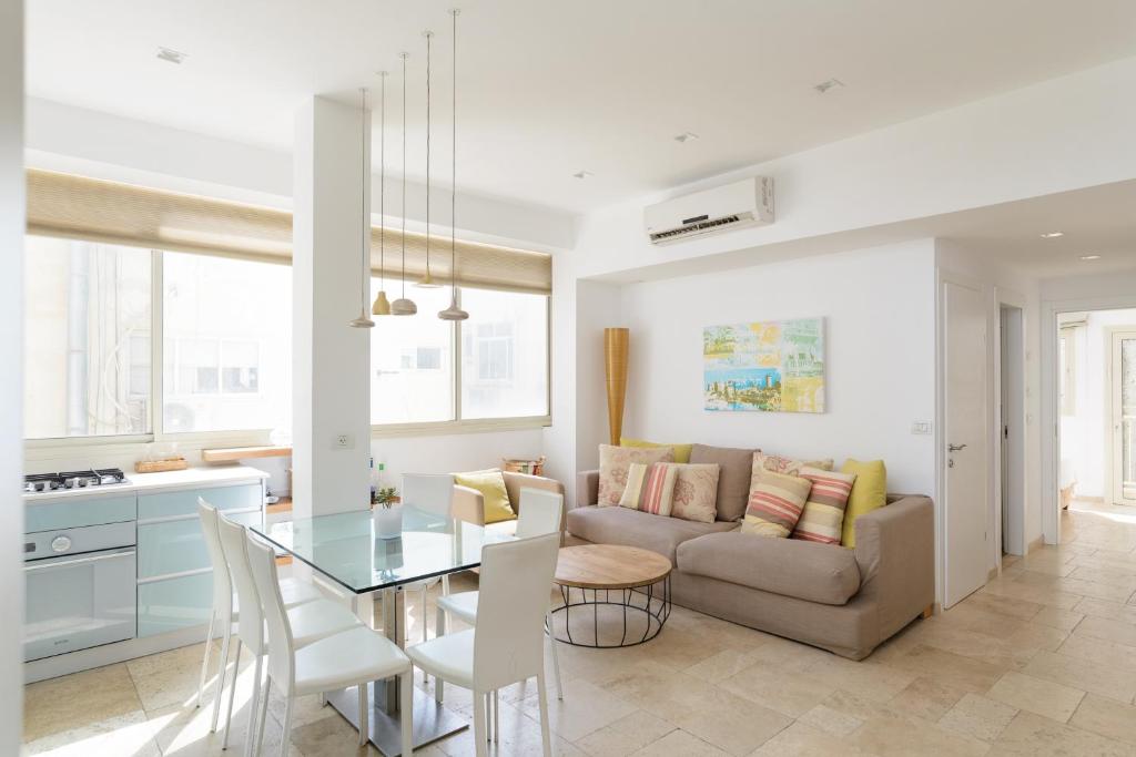 a kitchen and living room with a couch and a table at Adorable 2 bedrooms apt w Bomb Shelter next to the beach in Tel Aviv