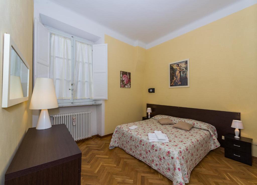 1 dormitorio con cama y ventana en Residence il Duomo, en Lucca