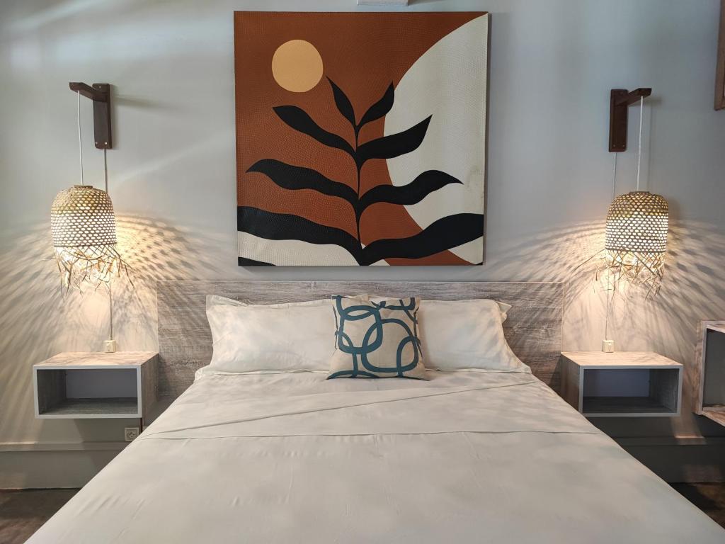 Ti Pavillon في Rodrigues Island: غرفة نوم بسرير كبير مع مواقف ليلتين