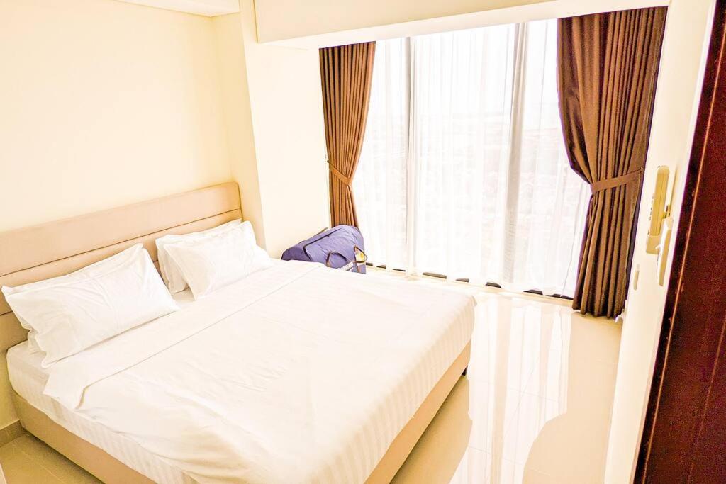 ein weißes Bett in einem Zimmer mit Fenster in der Unterkunft Lovina 3508 at Pollux Meisterstadt in Batam Center
