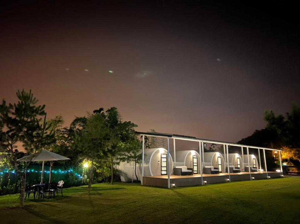 a house with a glass facade at night at Star & Moon GUEST HOUSE in Puli