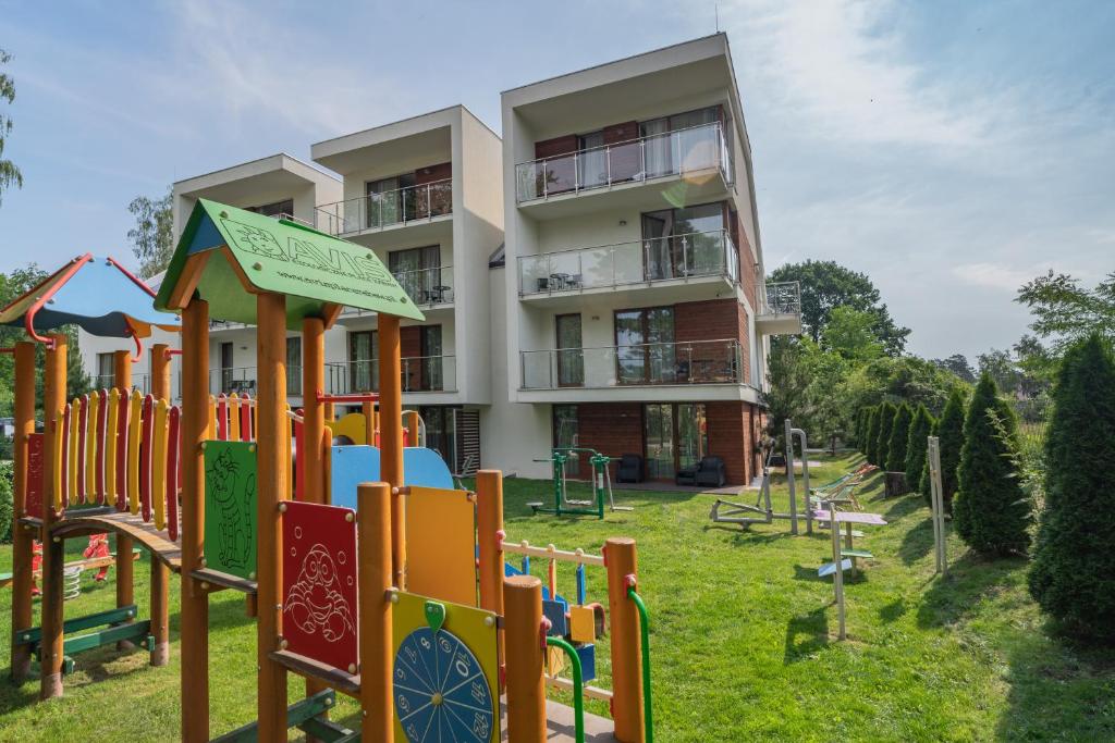 a building with a playground in front of a building at Apartamenty NCNK Stegna Forest in Stegna