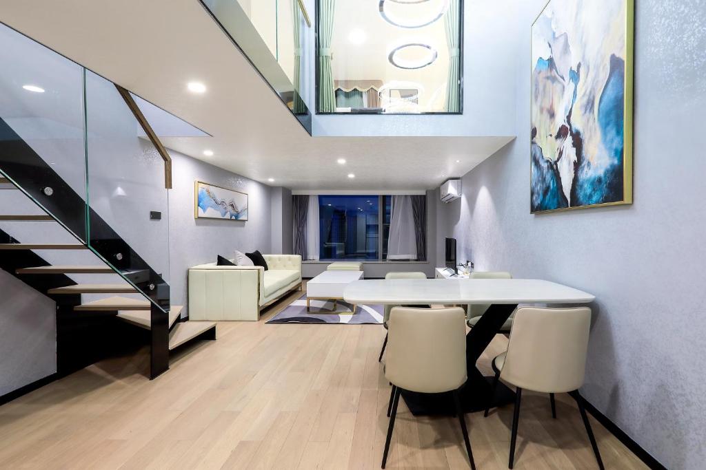 a living room with a white table and chairs at Shenzhen Fashion LOFT Apartment in Shenzhen