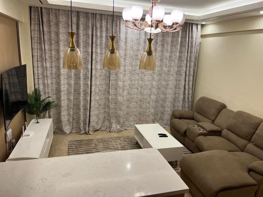 ein Wohnzimmer mit einem Sofa und einem Tisch in der Unterkunft Enzi Heights Apartment Block B in Nairobi