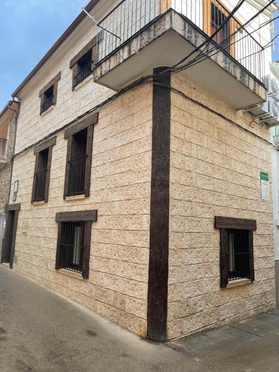 un edificio de ladrillo con ventanas y balcón en Apartamento rural jama, en Cilleros