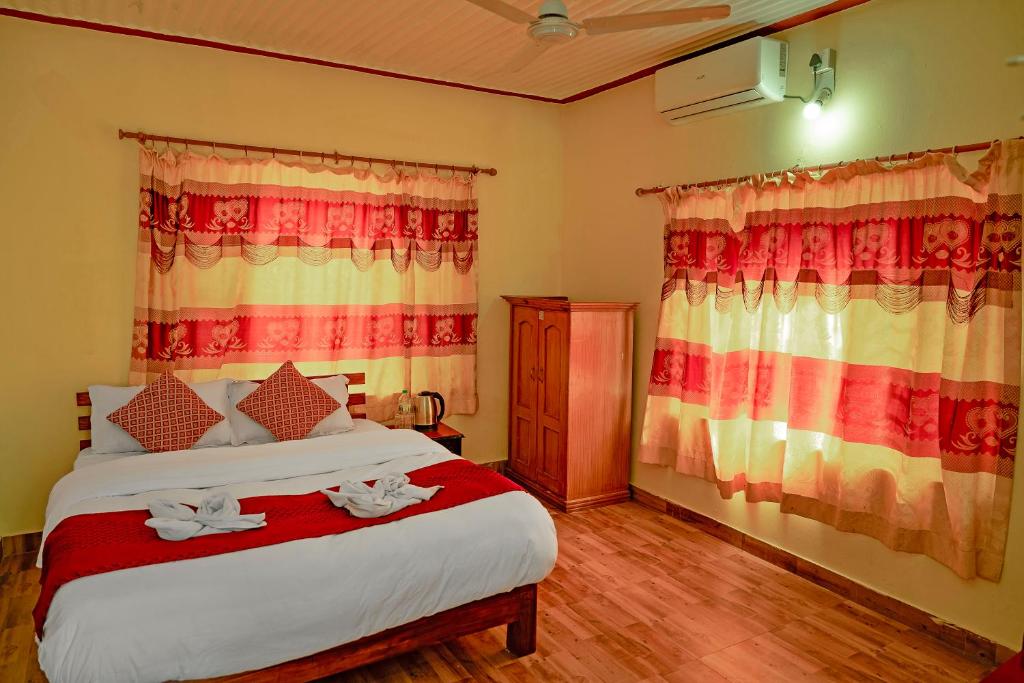 a bedroom with a bed with towels on it at Hotel Plaza Nepal in Pokhara