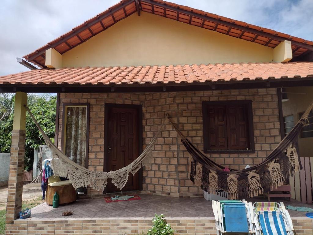 a small house with two chairs and a net at Chalés Ponta de Pedras in Alter do Chao