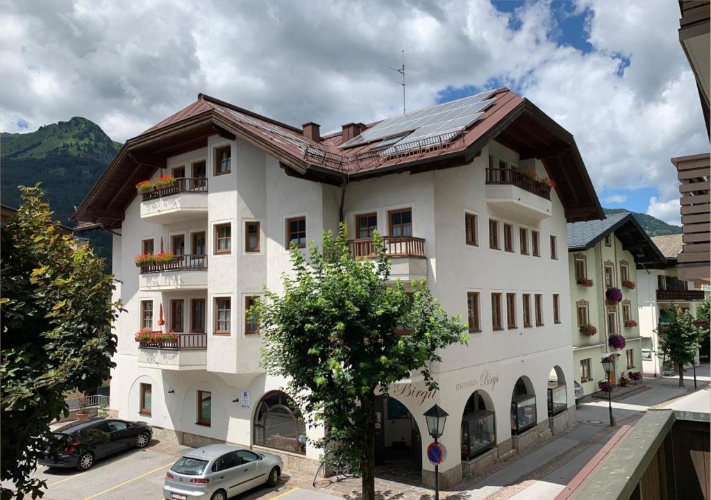 a white building with a brown roof at Ferienhaus Birgit - inklusive Eintritt Alpentherme Bad Hofgastein in Bad Hofgastein