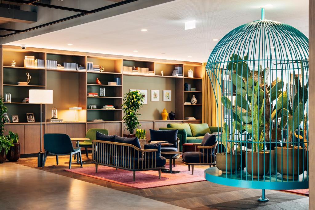 a lobby with couches and chairs and plants at Hotel Galántha in Eisenstadt