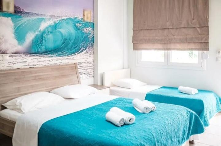 2 camas con toallas encima de ellas en un dormitorio en Studios Ioulia en Keramotí