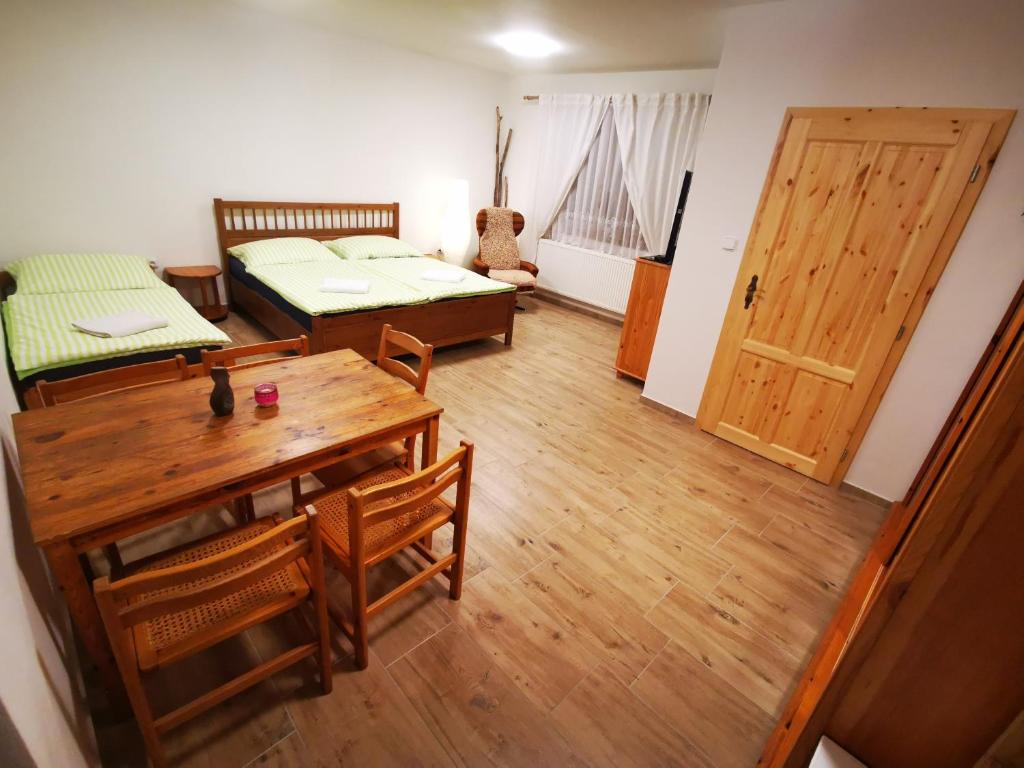 a room with two beds and a table and a door at Apartmán na Náměstí 55 in Drnholec