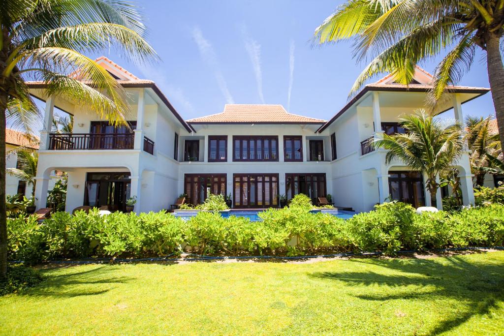 - une vue sur l'extérieur d'une maison avec des palmiers dans l'établissement Outstanding Villa In Beach Resort, à Đà Nẵng