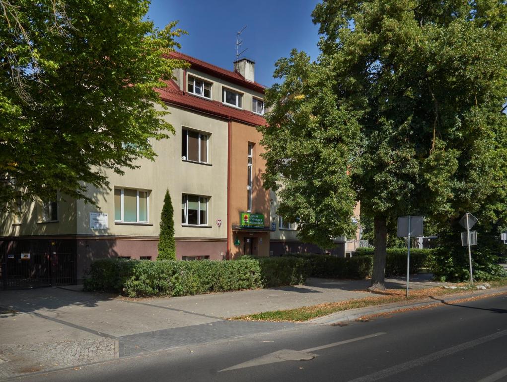 un edificio al lado de una calle con árboles en Szkolne Schronisko Mlodziezowe w Olsztynie, en Olsztyn