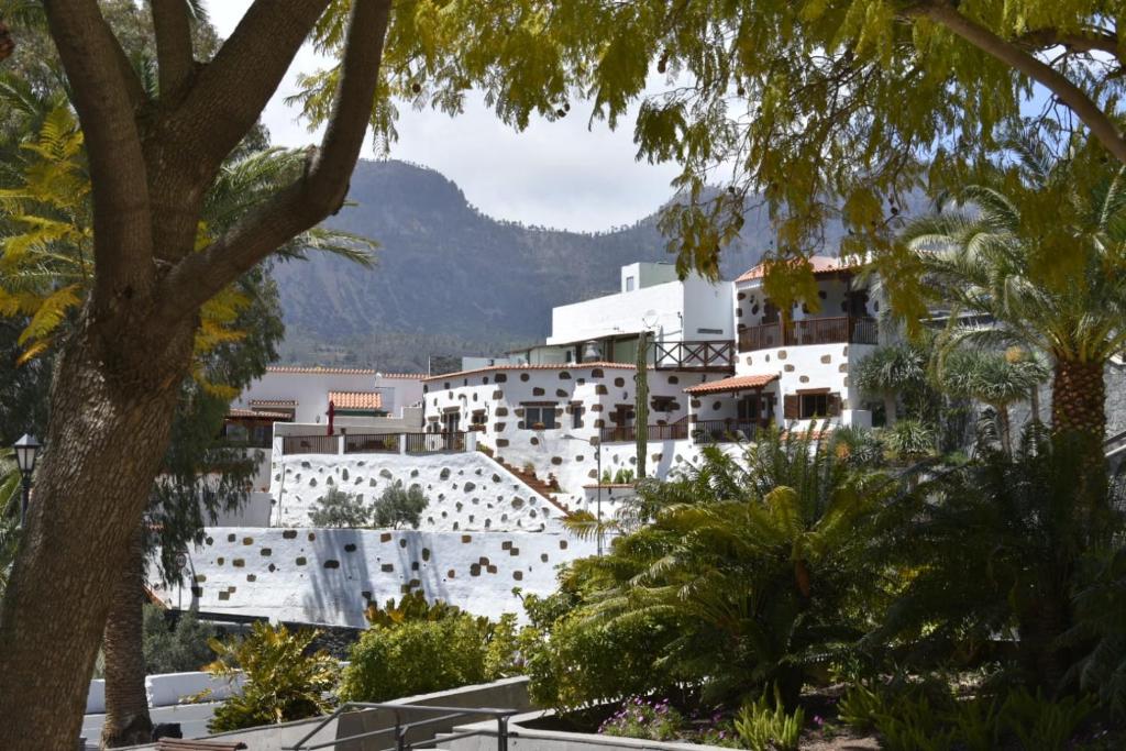 a white building with a mountain in the background at Holiday Cottage Santa Lucía 2 in Santa Lucía