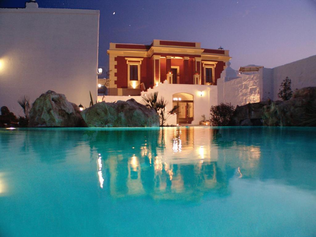 une piscine d'eau bleue devant une maison dans l'établissement Hotel Masseria Fortificata Donnaloia, à Monopoli