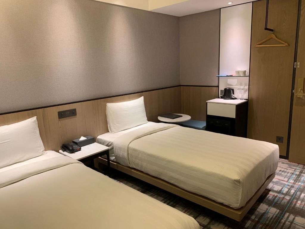 a hotel room with two beds and two toilets at Hotel Midtown Richardson in Taipei