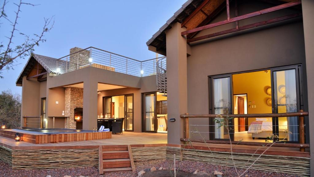 ein Haus mit einer Terrasse mit einem Whirlpool in der Unterkunft Mjejane Luxury Self-Catering Villa in Hectorspruit
