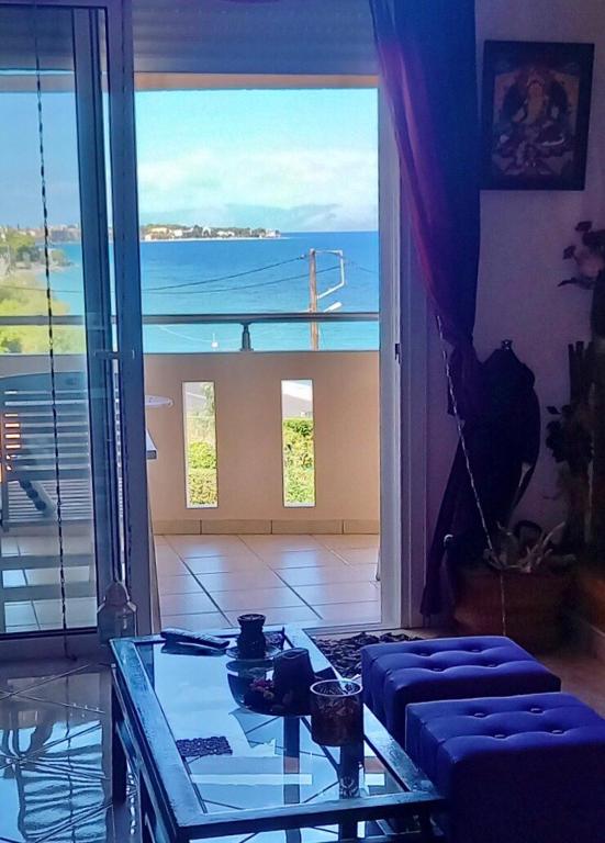 a living room with a glass table and a large window at Evi in Xylokastro