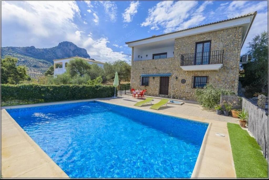 a swimming pool in front of a house at Balcón al Valle in El Gastor