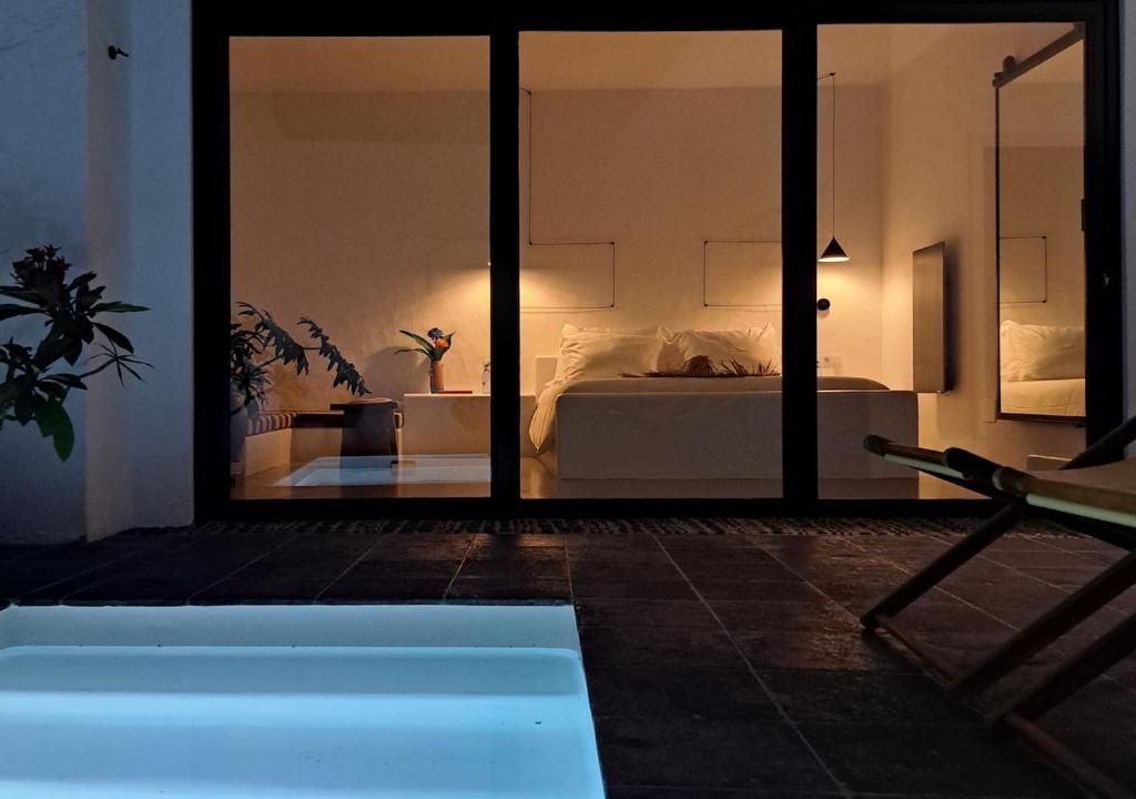 a bedroom with a bed and a swimming pool at Casa de las Flores - Hotel Boutique Lanzarote in Teguise