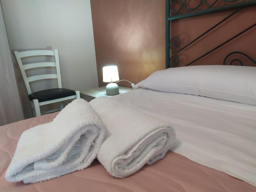 Un dormitorio con una cama con toallas blancas. en Grotta del Monaco, en Pedara