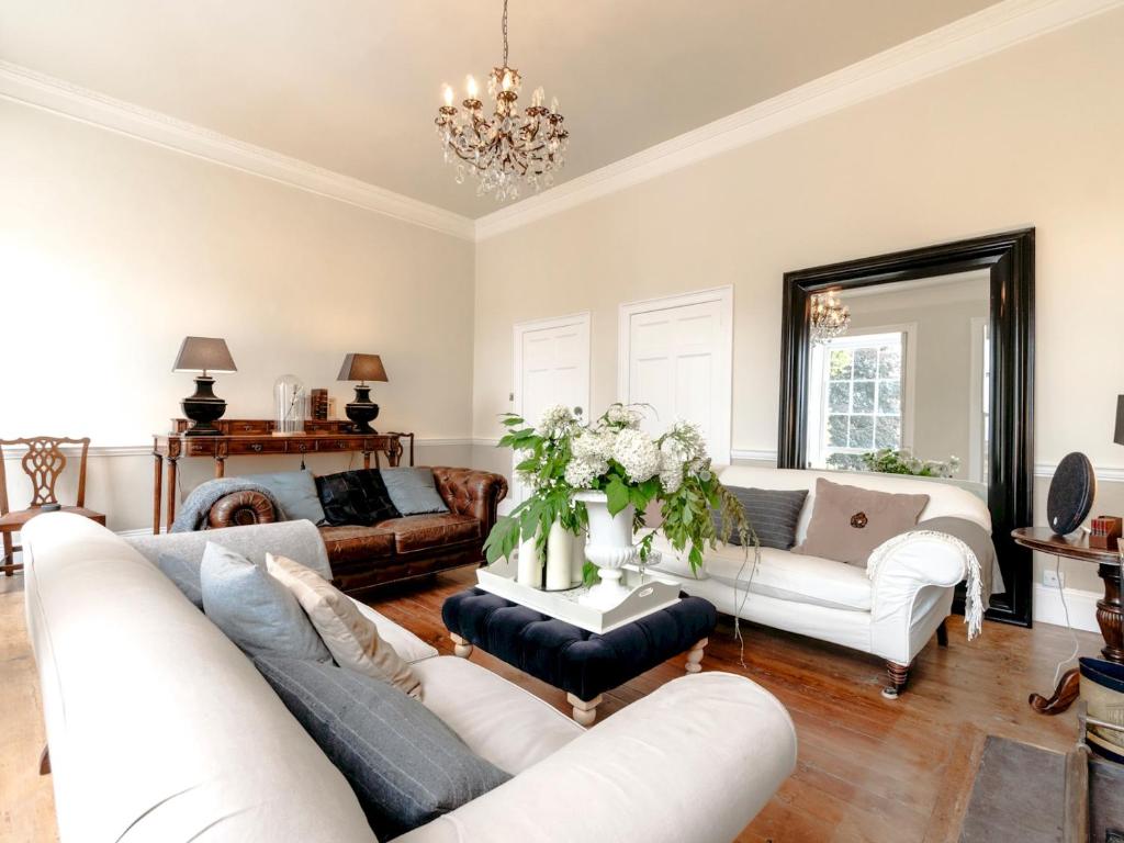 a living room with white furniture and a chandelier at Pass the Keys Elegant Georgian Townhouse in the heart Bath in Bath