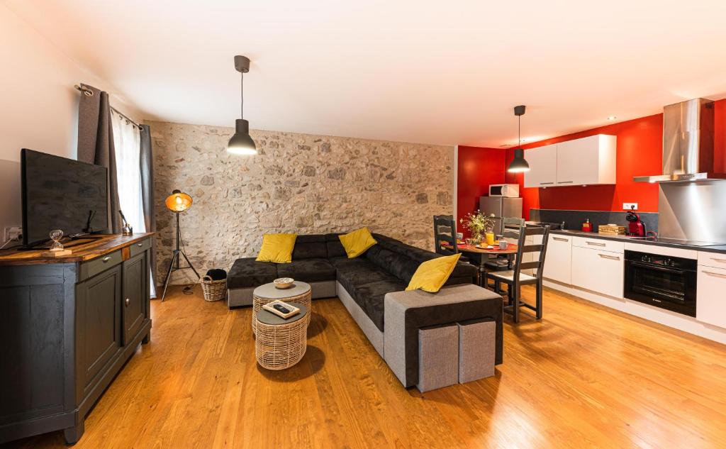 un soggiorno con divano e una cucina di Les Gîtes du château - L Appartement du Roi - Magnifique Appartement face au château a Nérac