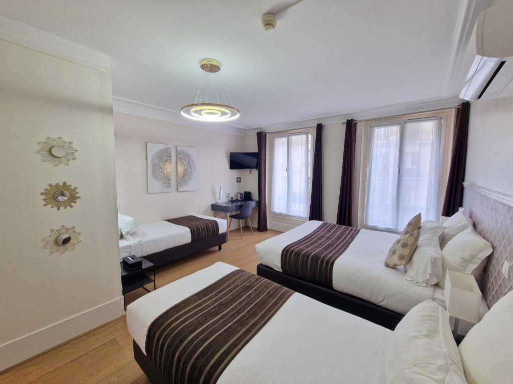 um quarto de hotel com duas camas e uma secretária em Hôtel Océanic - Grands Magasins em Paris