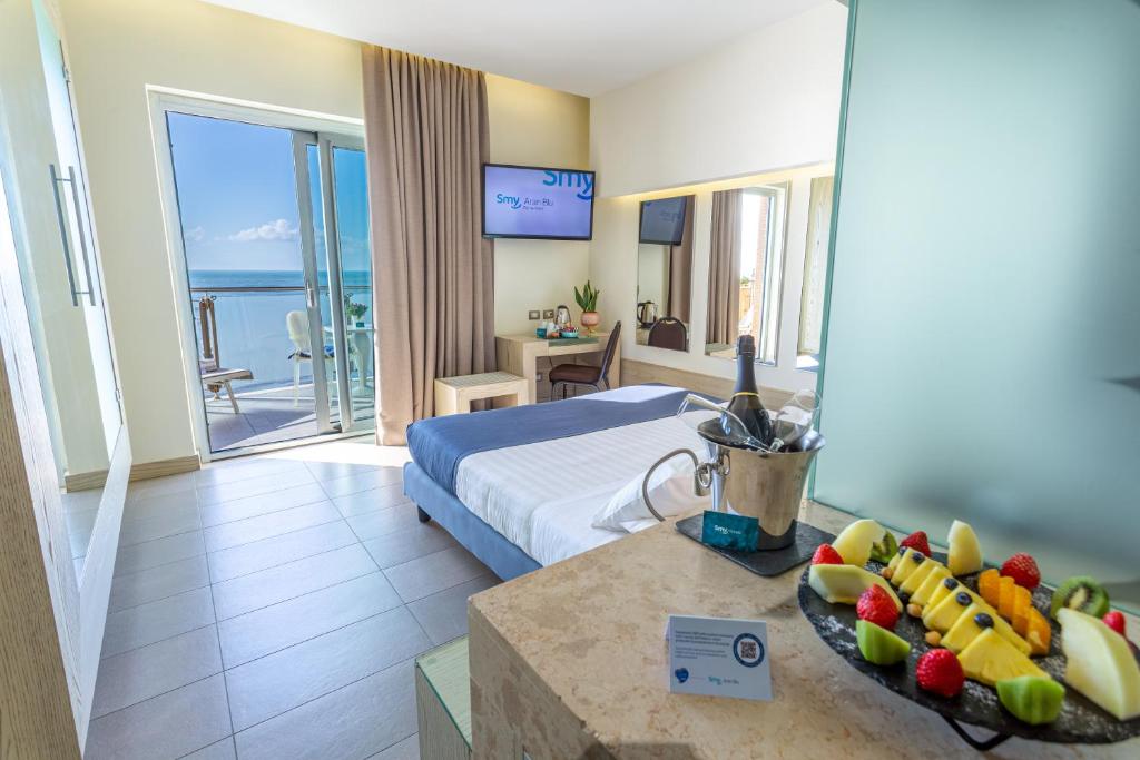 um quarto de hotel com uma cama e uma mesa com fruta em Smy Aran Blu Roma Mare em Lido di Ostia