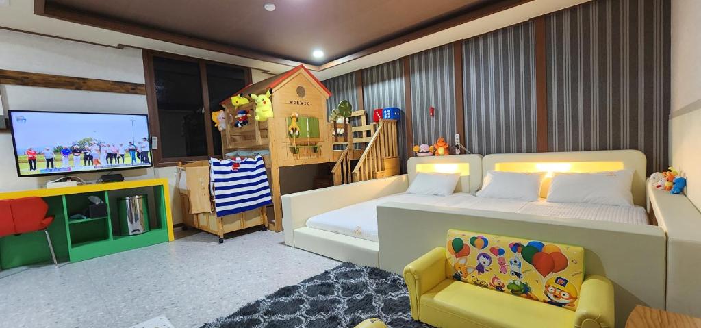 a bedroom with a bed and a tv and a couch at GyeongJu Kids & Family Hotel in Gyeongju