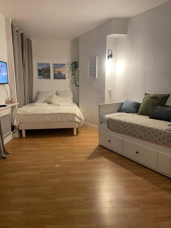 2 camas en una habitación con suelo de madera en Appartement a Paris en París