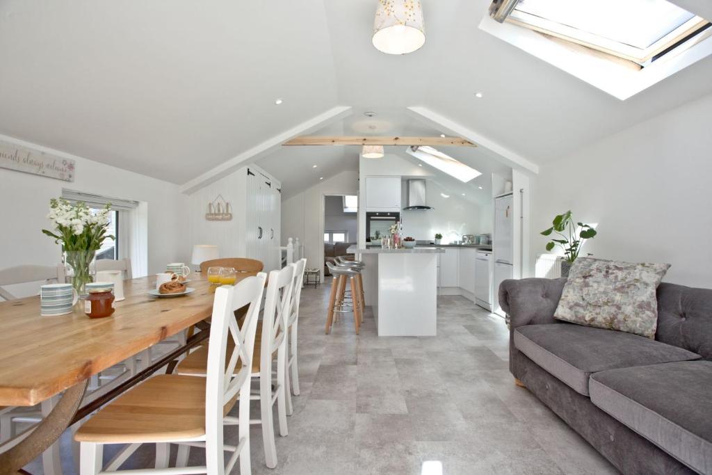 a kitchen and living room with a table and a couch at The Mews, Tresean in Newquay