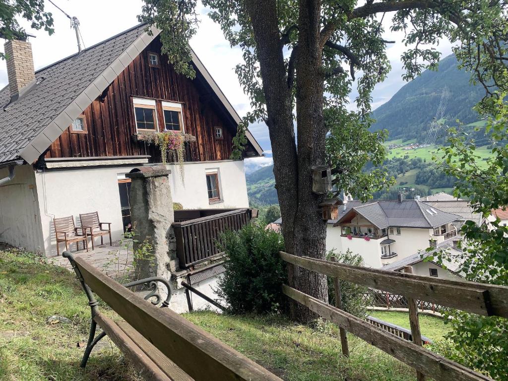 a wooden house with a bench in front of it at Ferienhaus Alpenglück in Wenns