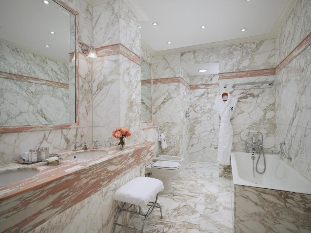 a bathroom with a tub and a toilet and a sink at The Ritz London in London