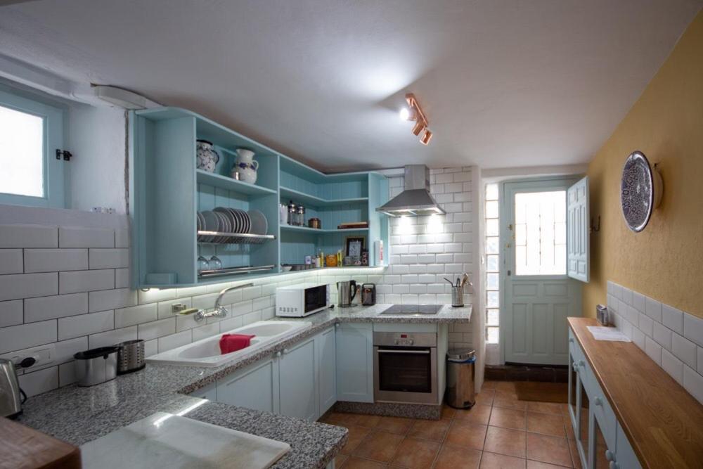 una cocina con armarios azules y fregadero en Casa Bonita Órgiva., en Órgiva