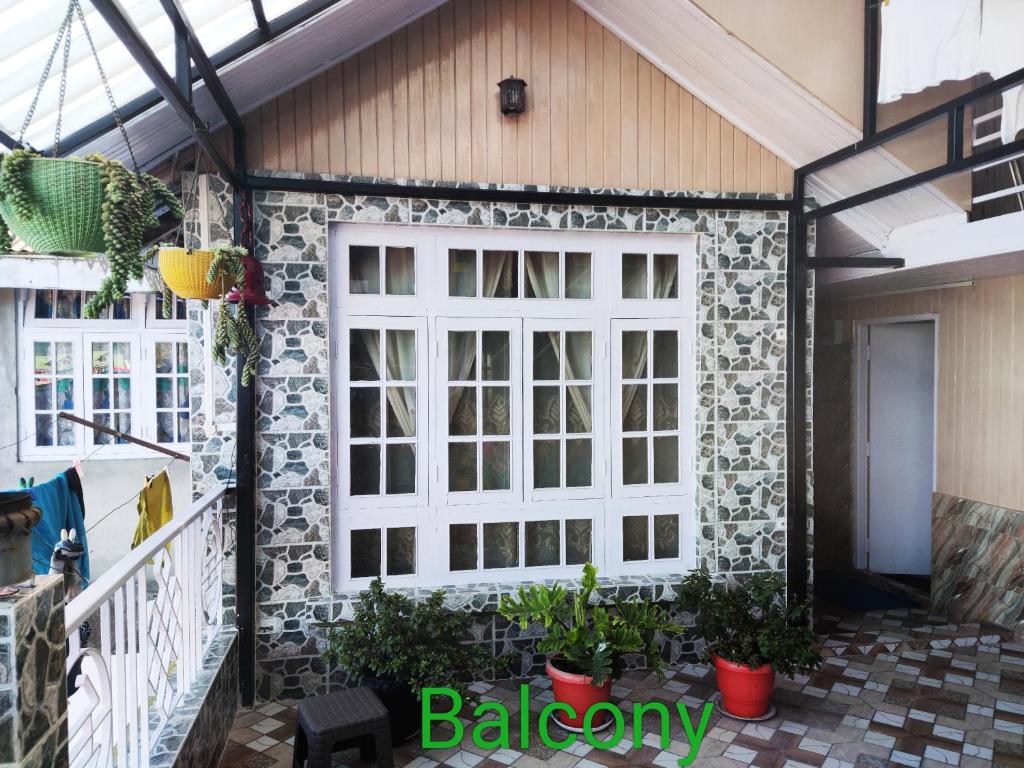un garaje con una puerta blanca y una pared de piedra en PRATIMA HOMESTAYS, en Darjeeling